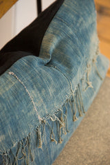 Sun-faded vintage African indigo textile, showing hand-stitched seams and frayed threads.