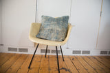 Sun-faded indigo blue textile with frayed threads on a vintage African pillow.