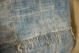 Vintage African indigo pillow close-up, sun-faded blue textile with original stitching.