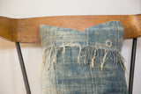 Frayed fringe and textured, sun-faded blue textile of an African Indigo pillow.