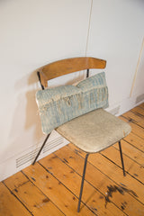 Sun-faded African Indigo handmade pillow with textured blue weave and raw fringed edge.