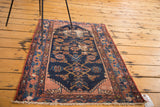Decorative distressed Malayer rug, with faded Herati pattern in navy and dusty rose.