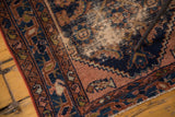 Distressed antique Malayer rug with worn dusty rose pile and navy Herati motifs.