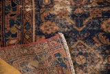 Close-up of distressed Malayer rug's Herati pattern, secured red edge, and reverse weave.