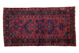 Vintage Lilihan rug features a mirrored tree of life design in raspberry red and navy blue.