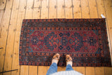 Traditional vintage Lilihan rug, raspberry and blue mirrored tree of life, shown with feet.