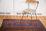 Mirrored tree of life design on the vintage Lilihan rug in raspberry red and blue.