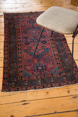 Hand-knotted Lilihan rug corner displaying raspberry red, navy, cobalt blue motifs and fringe.