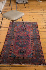 Vintage Lilihan rug corner with raspberry red, blue tree of life pattern and fringe.