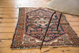 Textured navy blue Herati field and madder root red border on a distressed Malayer rug.