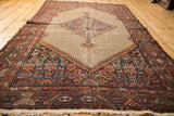 Decorative distressed texture on a vintage Hamadan rug, with central medallion and borders.