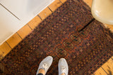 Distressed vintage Turkmen rug featuring a faded raspberry red gul design with worn edges.
