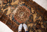 Vintage Malayer rug detail: distressed auburn red, camel, slate blue pile with tattered edges.