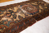 Distressed vintage Malayer rug with tattered edges, featuring camel, slate blue, and auburn red.