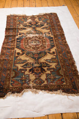 Lower edge of distressed Malayer rug with tattered fringe and faded, worn pile.