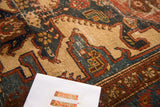 Distressed vintage Malayer rug's geometric pattern with worn camel, slate blue, and auburn red.