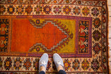 Stepped tangerine mehrab outline and geometric border patterns on vintage Oushak rug.