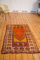 Corner detail of vintage Oushak prayer rug with tangerine orange mehrab and geometric border.