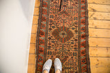 Finely woven Vintage Malayer rug's detailed central flower, blush field, and tattered edge.