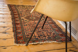 Vintage Malayer rug's finely woven geometric floral pattern on dusty blush field, with worn fringe.