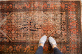 Heavy distress visible on the madder red Herati field of this antique Malayer rug.