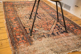 Textural distress and tattered edge on an antique Malayer rug, apricot and navy.