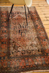 Distressed Malayer rug corner, tattered edges, Herati field, in madder red and slate blue.