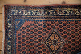 Corner view of a vintage Engelas rug highlighting its hand-knotted pile and traditional navy border.