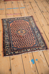 Angled view of a vintage Engelas rug mat, highlighting its salmon field and navy geometric motifs.