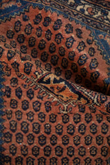 A soft fold in the vintage Engelas rug showing its dense, rust-colored hand-knotted pile.