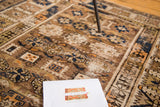 Distressed antique Kuba rug's geometric pattern in aged mauve, indigo, and tangerine.