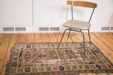 Distressed antique Kuba rug featuring faded geometric patterns in indigo, ivory, and tangerine.