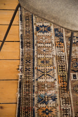 Distressed side edge of a hand knotted antique Kuba rug with geometric motifs.