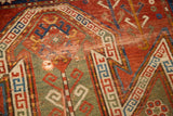 Distressed antique Sewan Kazak rug with fragmented shield patterns in madder red, olive, and tatter.