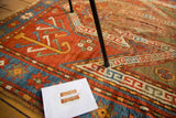 Rich madder red and sky blue geometric patterns on an aged hand-knotted Sewan Kazak rug.