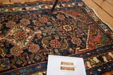 Textured Herati design on a distressed Hamadan runner in navy, madder red, and ivory.