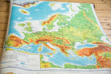 Vintage pictorial relief map of Europe, detailing western and central topography in green and orange tones.