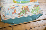 Lower edge of vintage Europe map with wooden dowel separating from torn turquoise backing.