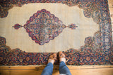 Upper corner of distressed Kerman rug, showing rococo floral spandrel and milfleur border.