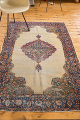 Distressed Kerman rug corner, milfleur border, and rococo leaves in blue, red, and cream.