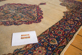 Distressed Kerman rug detail: ivory field contrasting with rococo milfleur border.