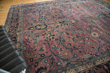 Vintage Meshed rug detail: time-softened plum field, navy tendrils, blossomed flowers, Safavid border.
