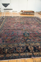 Intricate Safavid-inspired main border with plum, navy, and teal florals on a vintage Meshed rug.