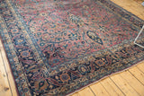 Vintage Meshed carpet corner, navy Safavid border, plum and teal tree of life motifs.