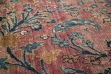 Intricately woven delicate tendrils and blossoms in plum, navy, and ivory on vintage Persian Meshed rug.