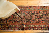 A section of distressed antique Northwest Persian runner featuring brick red and indigo Herati floral motifs.