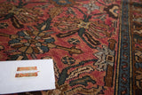Lilihan rug's ruby rose field featuring serrated leaves, palmettes, teal, and bronze.