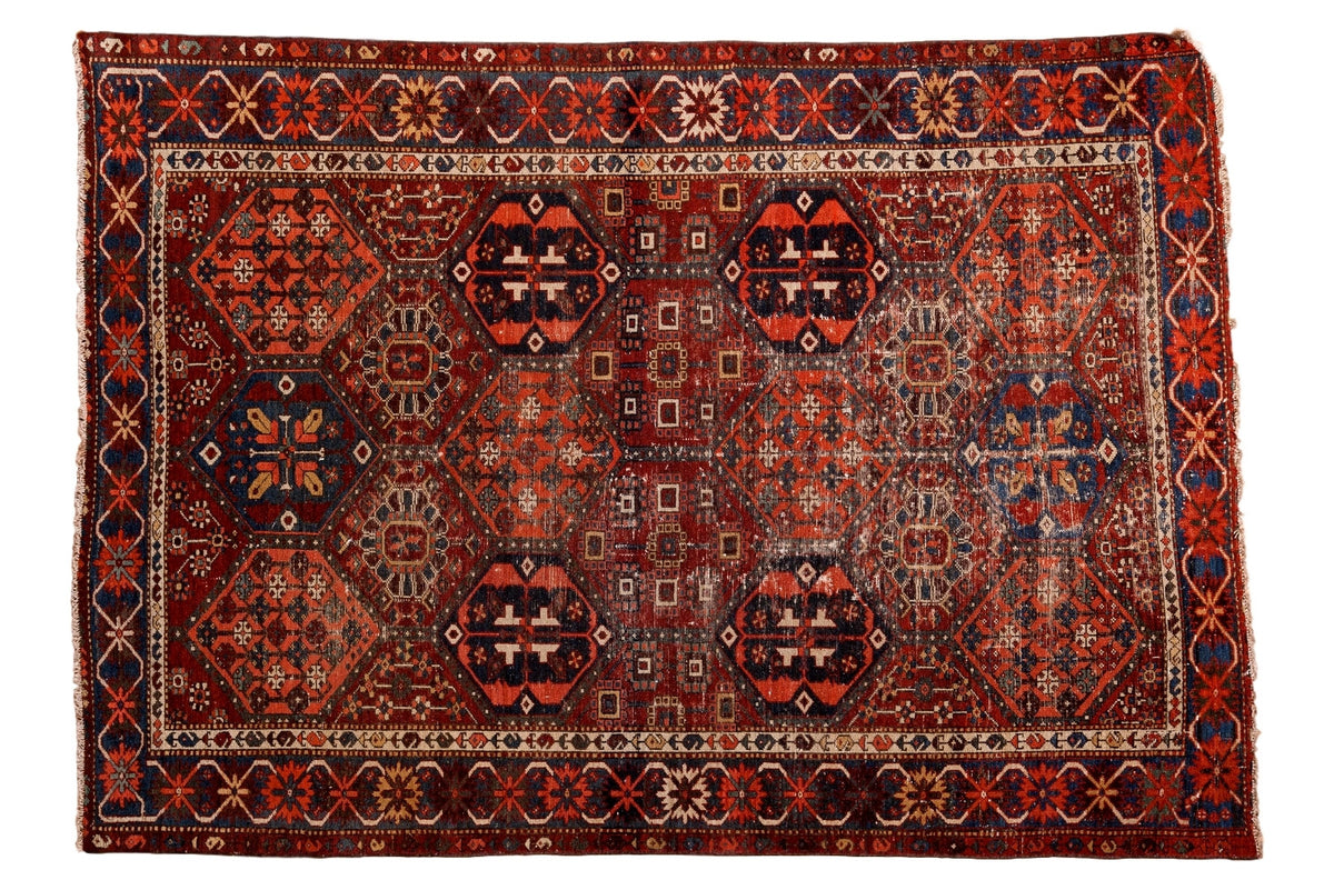 Antique distressed Baktiari rug, repeating cherry red, navy, saffron geometric panels, crab border.