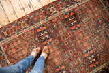 Decorative distressed texture on multi-paneled antique Baktiari rug in cherry red and navy.