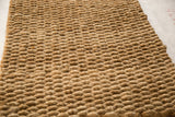 Close-up of the natural, tightly hand-braided texture of the gold entrance mat.